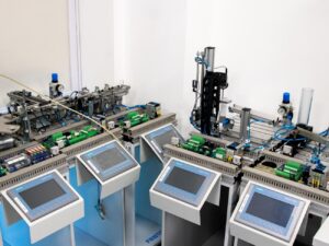 Sistema de automatización industrial con paneles de control y módulos de PLC en un laboratorio de formación, mostrando equipos didácticos de control de procesos para cursos de automatización