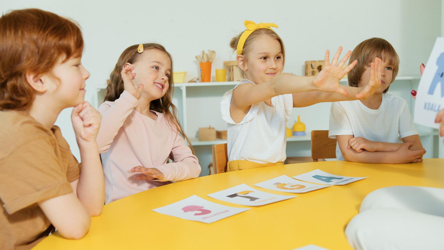 Niños de educación infantil participando en una situación de aprendizaje lúdica con tarjetas Niños de educación infantil participando en una situación de aprendizaje lúdica con tarjetas