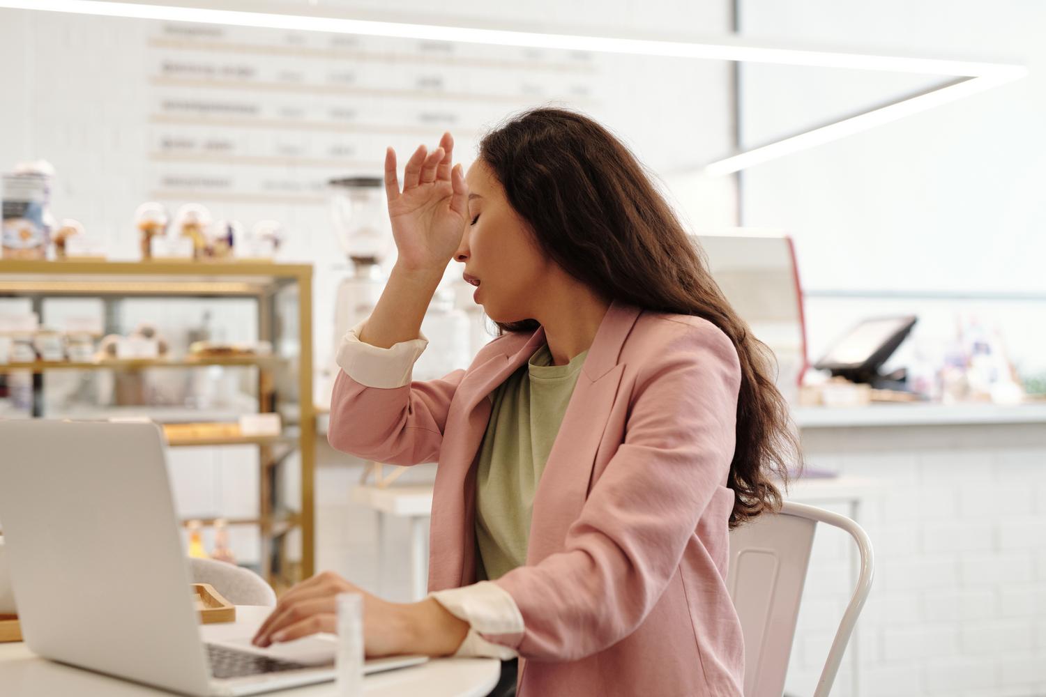 Mujer trabajadora sintiéndose mal y fatigada frente al ordenador debido a las altas temperaturas. Mujer trabajadora sintiéndose mal y fatigada frente al ordenador debido a las altas temperaturas.