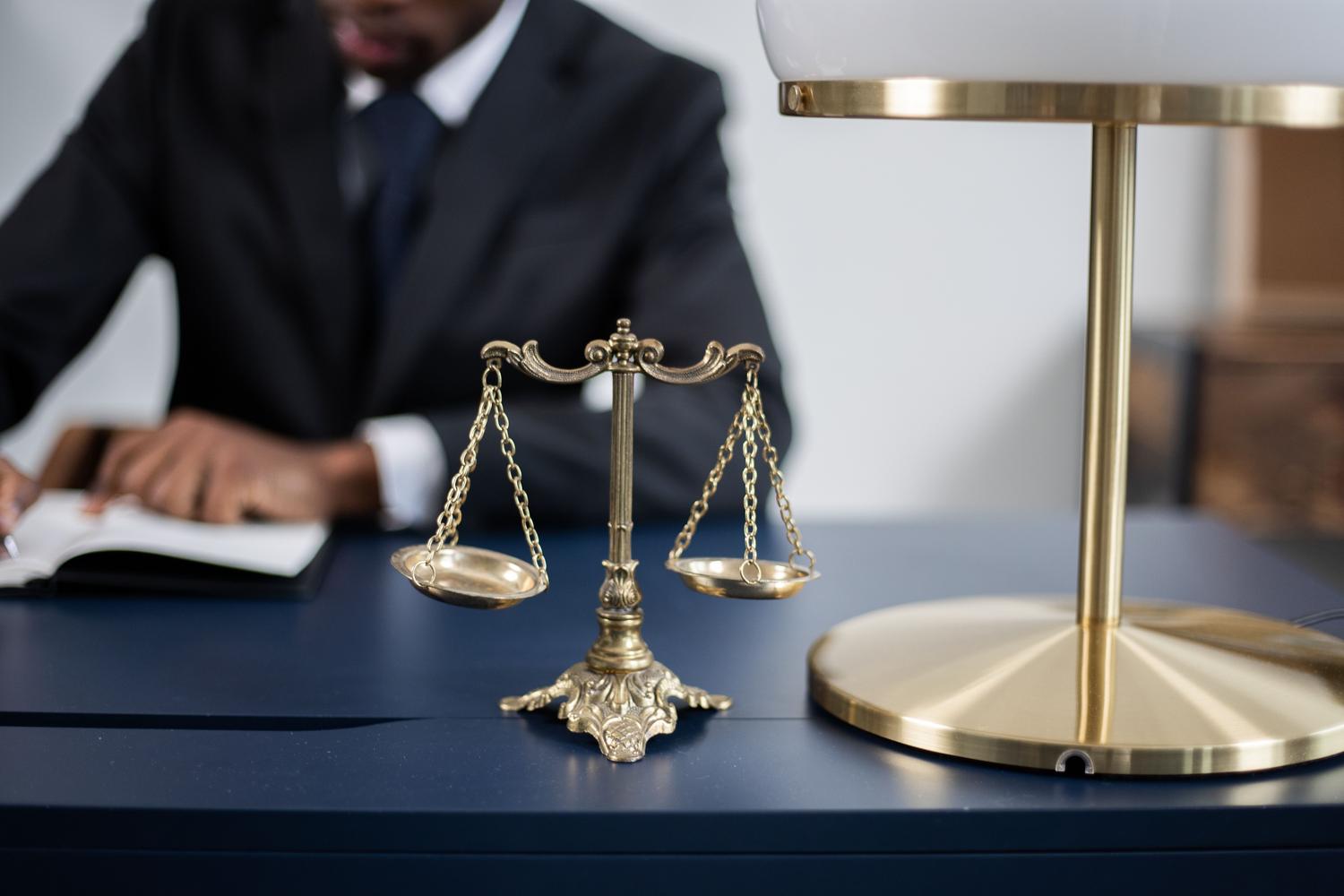 Balanza de la justicia sobre un escritorio oscuro, simbolizando el equilibrio y la aplicación de la ley. Balanza de la justicia sobre un escritorio oscuro, simbolizando el equilibrio y la aplicación de la ley.