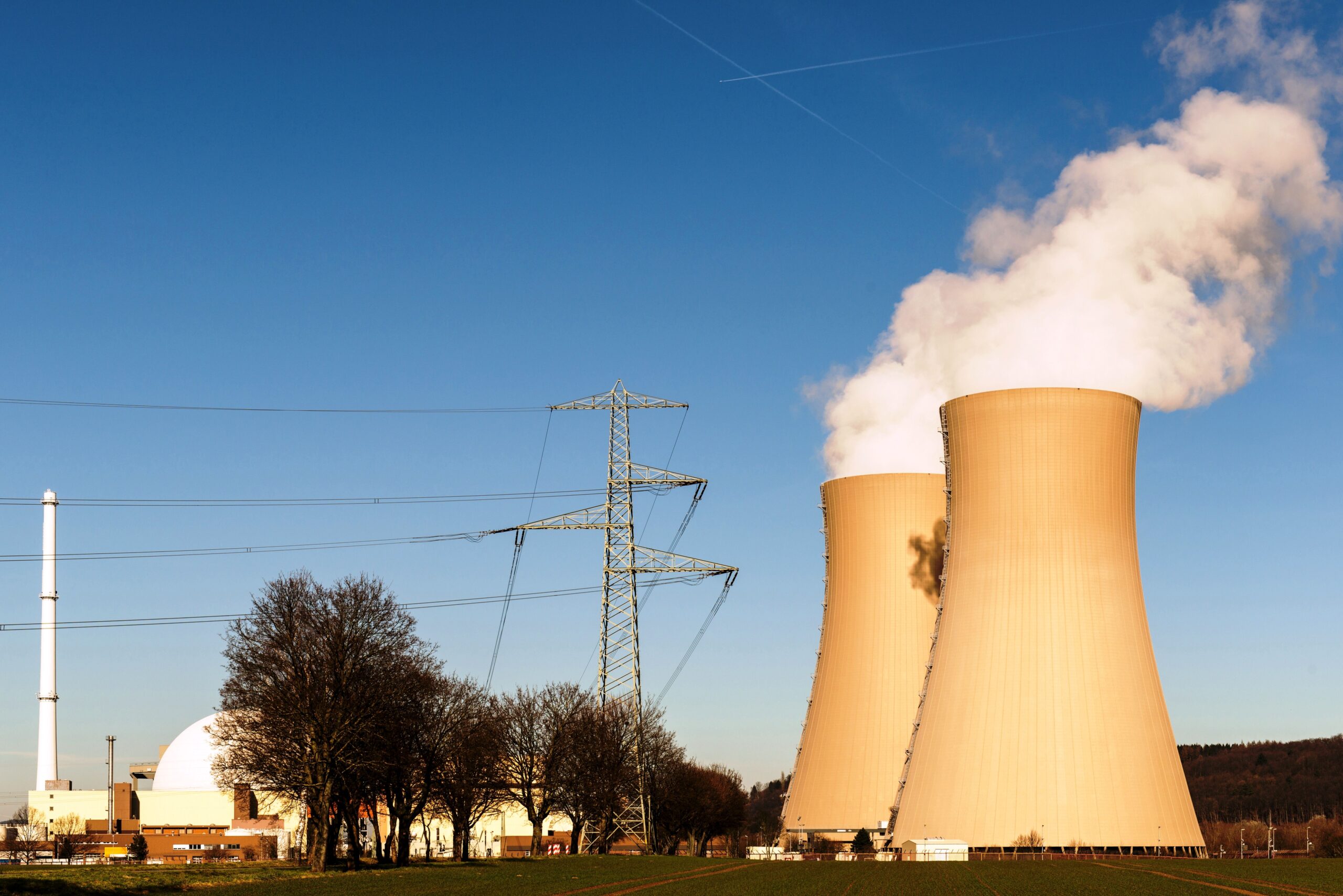 Vista de una central nuclear con sus torres de refrigeración, destacando la energía constante y baja en carbono necesaria para los nodos de procesamiento. Vista de una central nuclear con sus torres de refrigeración, destacando la energía constante y baja en carbono necesaria para los nodos de procesamiento.