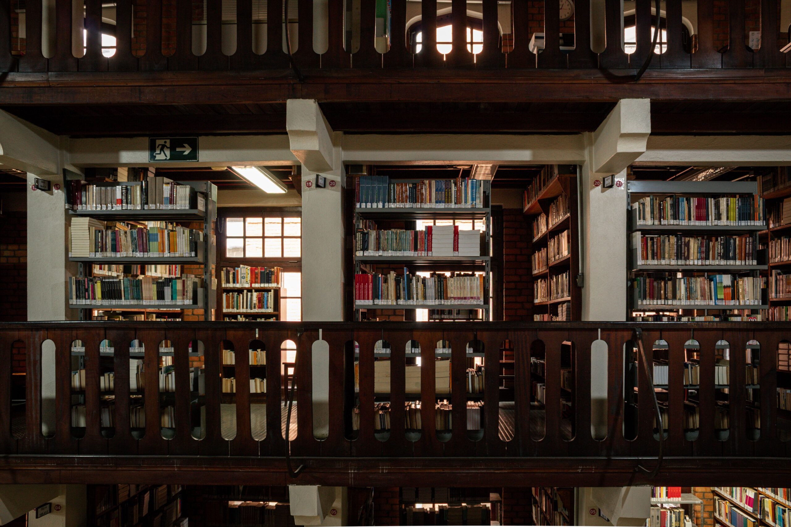 Interior de una biblioteca académica con múltiples niveles de estanterías, representando la búsqueda de fuentes bibliográficas. Interior de una biblioteca académica con múltiples niveles de estanterías, representando la búsqueda de fuentes bibliográficas.