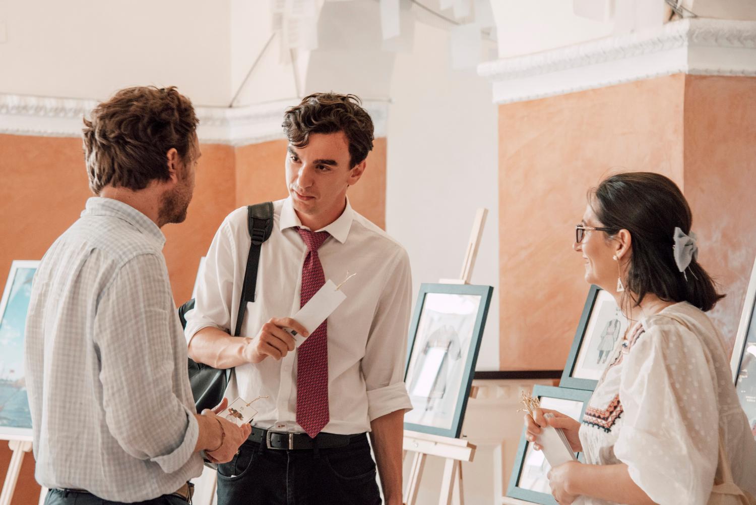 Tres profesionales conversando en una galería de arte, representando el tejido de relaciones sólidas en el fundraising cultural. Tres profesionales conversando en una galería de arte, representando el tejido de relaciones sólidas en el fundraising cultural.