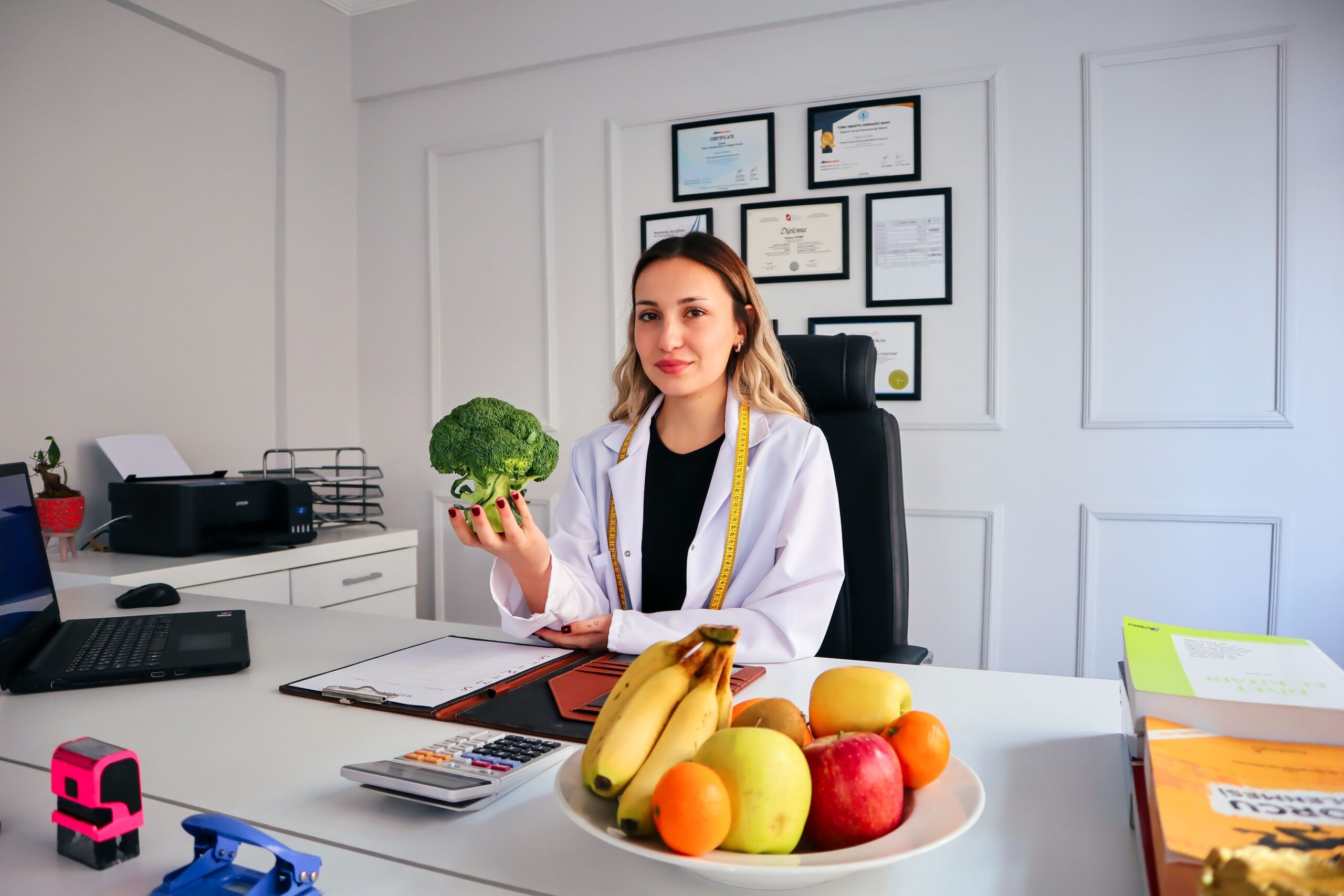 Nutricionista profesional en su consulta asesorando sobre alimentación saludable con ejemplos de frutas y verduras. Nutricionista profesional en su consulta asesorando sobre alimentación saludable con ejemplos de frutas y verduras.