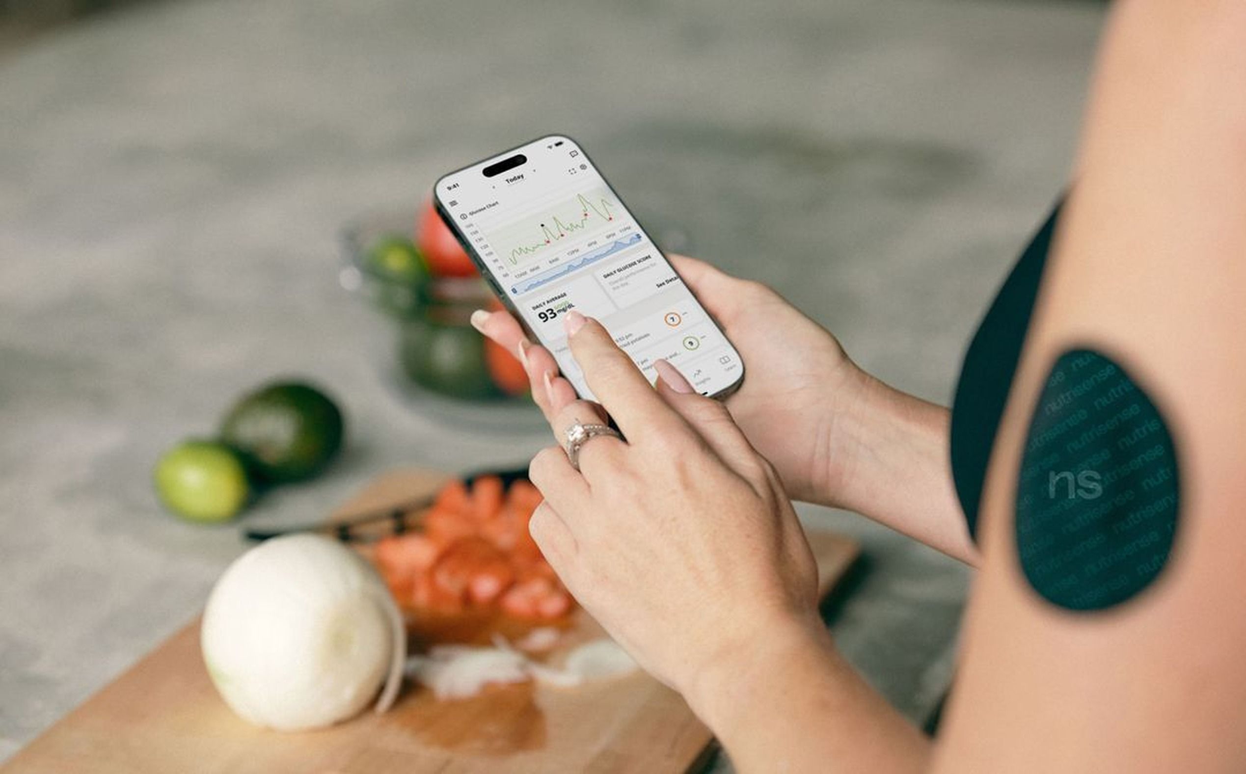 Persona utilizando una aplicación móvil y un sensor de glucosa para monitorizar su nutrición personalizada. Persona utilizando una aplicación móvil y un sensor de glucosa para monitorizar su nutrición personalizada.
