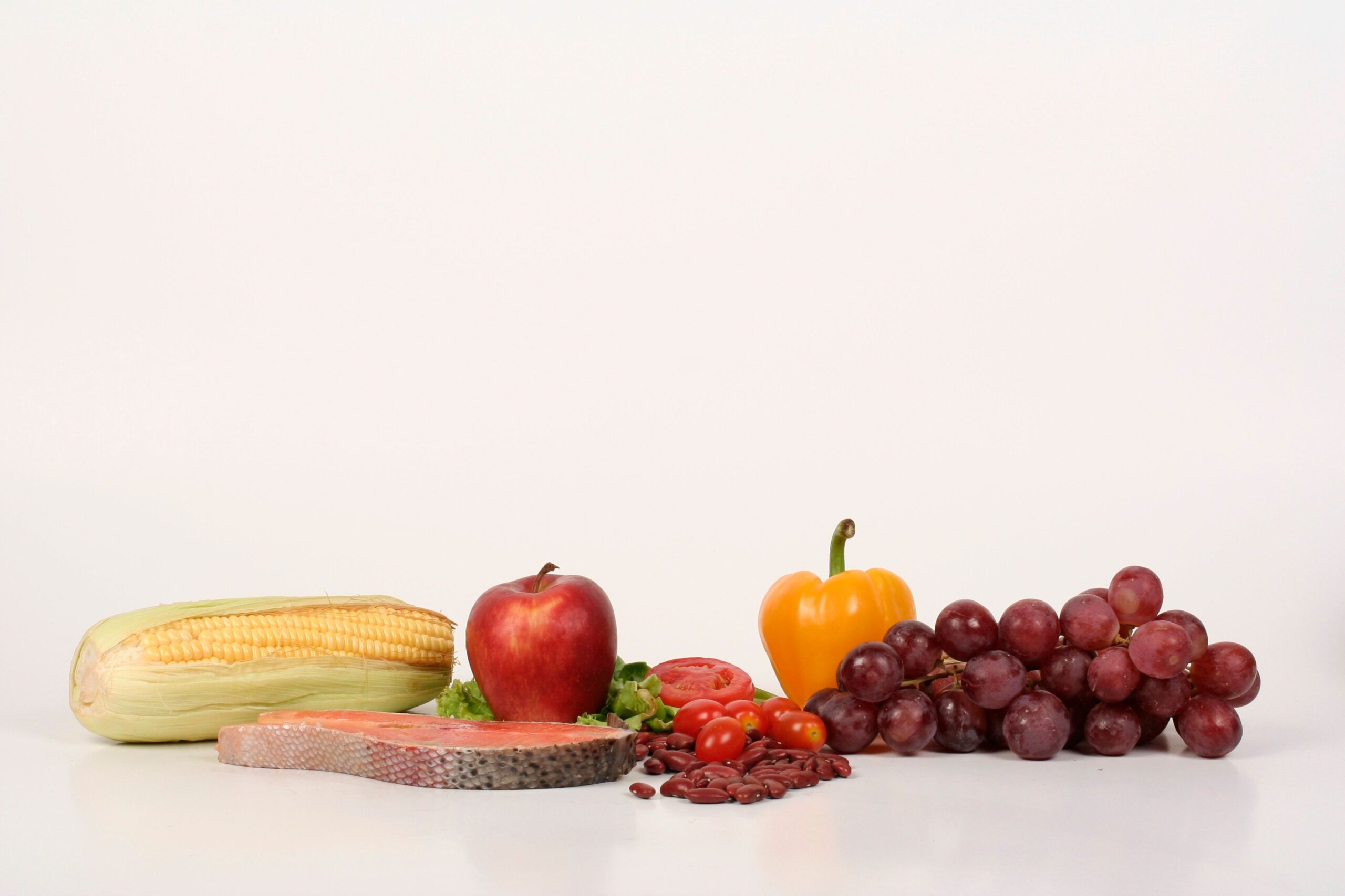 Variedad de alimentos frescos y nutritivos, incluyendo salmón, frutas y verduras, representando una dieta equilibrada. Variedad de alimentos frescos y nutritivos, incluyendo salmón, frutas y verduras, representando una dieta equilibrada.