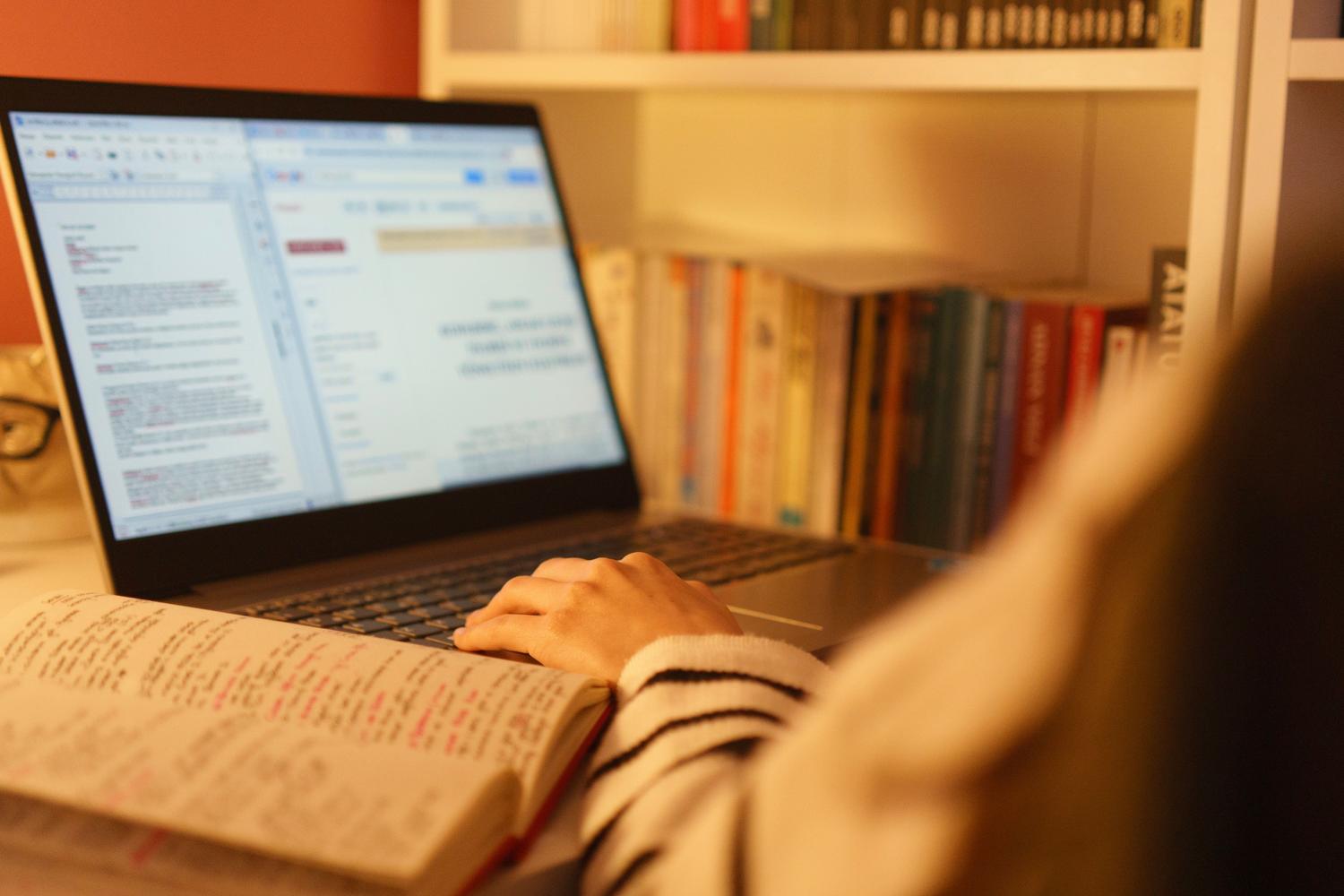 Persona estudiando oposiciones con laptop y libros en un entorno acogedor Persona estudiando oposiciones con laptop y libros en un entorno acogedor