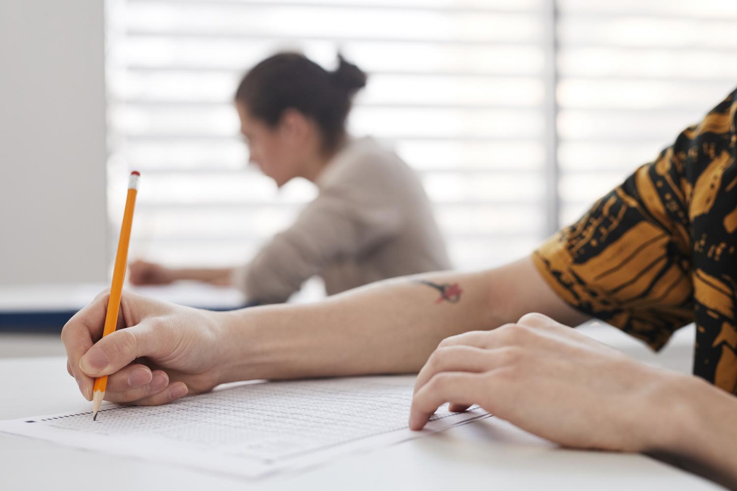 Primer plano de manos escribiendo en un examen de oposición Primer plano de manos escribiendo en un examen de oposición