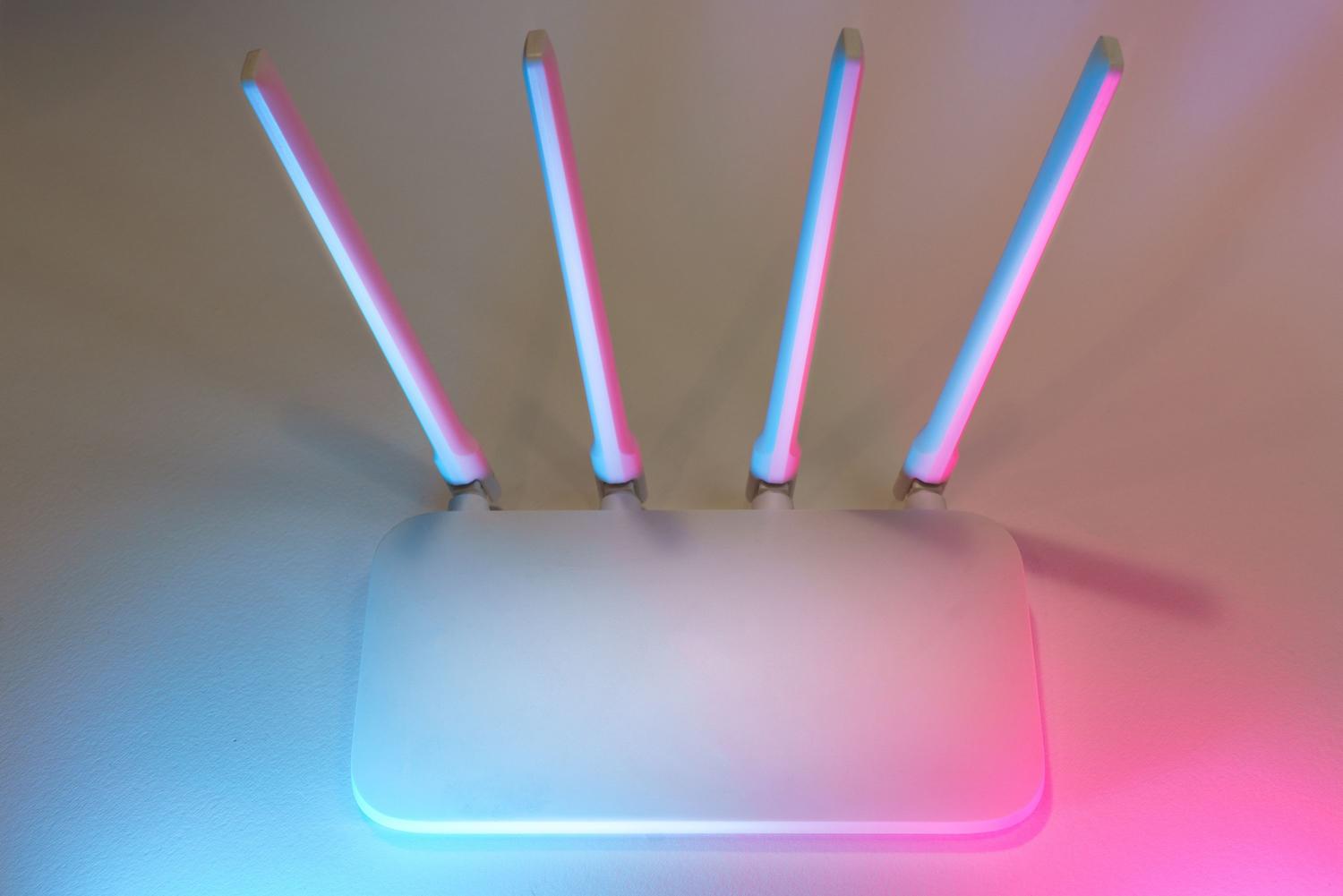 Router inalámbrico moderno de color blanco con cuatro antenas para una conexión WiFi estable. Router inalámbrico moderno de color blanco con cuatro antenas para una conexión WiFi estable.