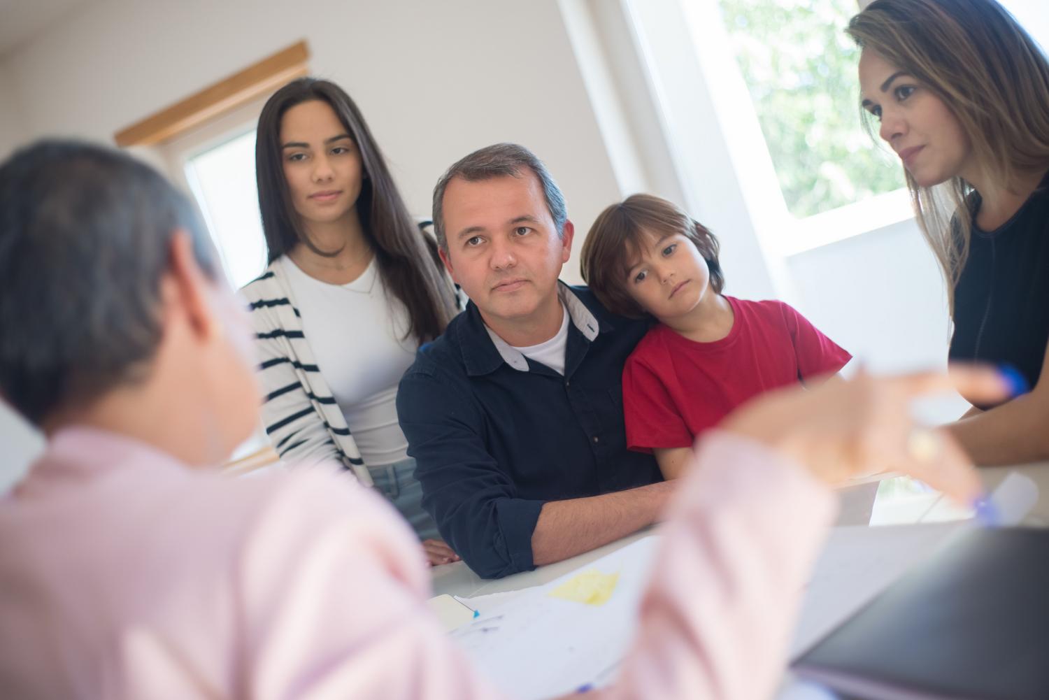 Una familia en una consulta con un profesional, simbolizando la alianza entre familia y escuela y la intervención de equipos multidisciplinares. Una familia en una consulta con un profesional, simbolizando la alianza entre familia y escuela y la intervención de equipos multidisciplinares.