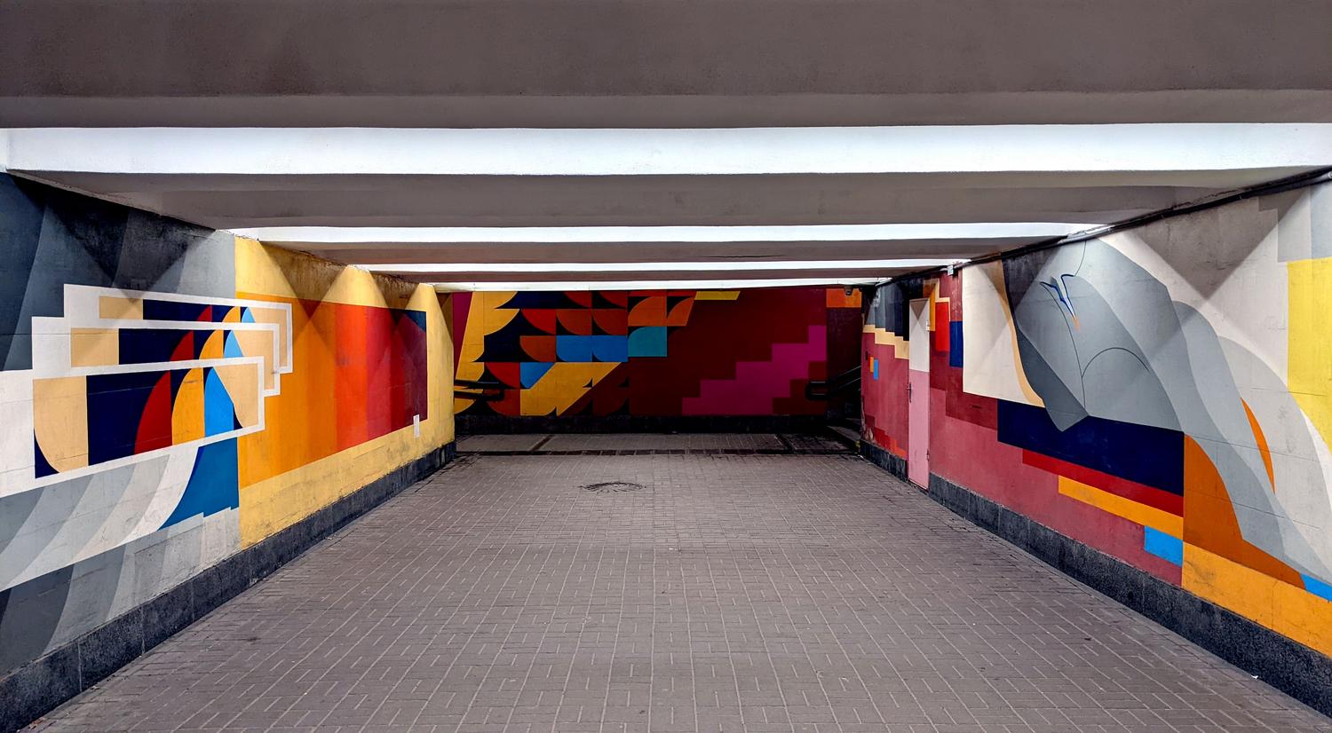 Arte urbano abstracto y geométrico en un paso subterráneo público con colores vibrantes. Arte urbano abstracto y geométrico en un paso subterráneo público con colores vibrantes.
