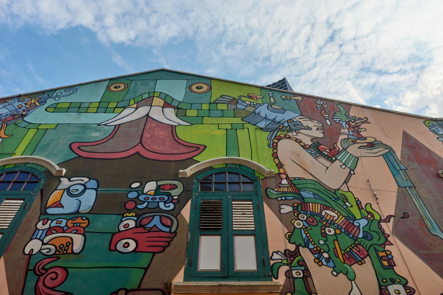 Mural con iconografía indígena mesoamericana en la fachada de un edificio, representando la identidad y resiliencia en Latinoamérica. Mural con iconografía indígena mesoamericana en la fachada de un edificio, representando la identidad y resiliencia en Latinoamérica.