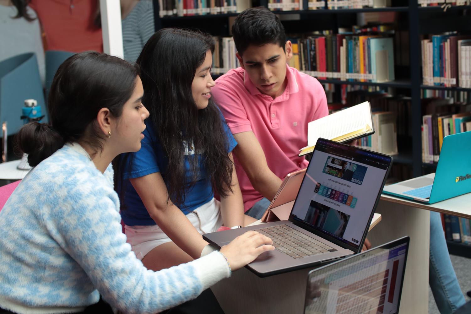 Grupo de jóvenes investigadores colaborando en una biblioteca con ordenadores portátiles, uniendo la academia con las herramientas digitales. Grupo de jóvenes investigadores colaborando en una biblioteca con ordenadores portátiles, uniendo la academia con las herramientas digitales.