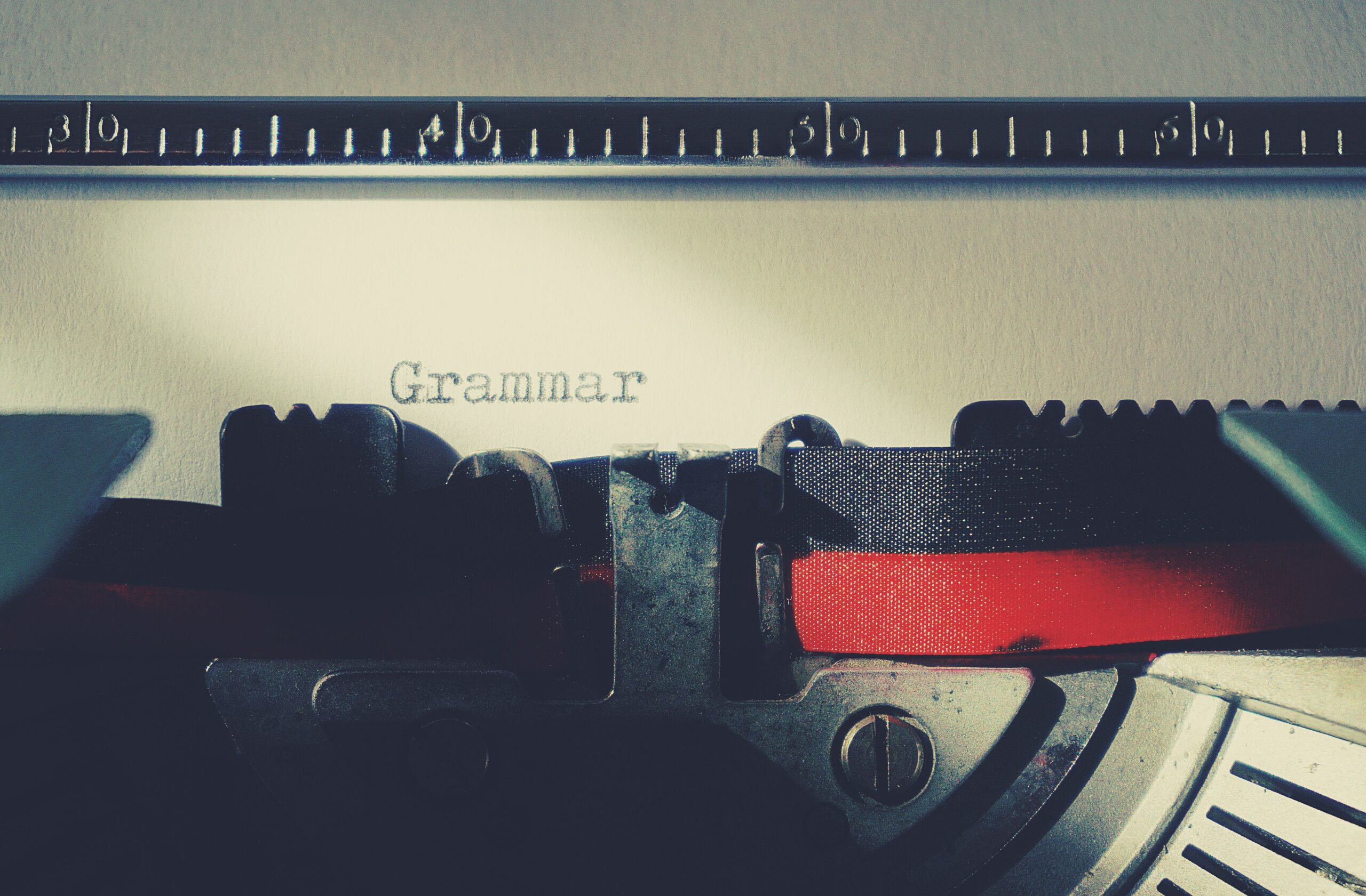 Primer plano de una máquina de escribir vintage mecanografiando la palabra 'Grammar', simbolizando el cuidado y la precisión en la escritura. Primer plano de una máquina de escribir vintage mecanografiando la palabra 'Grammar', simbolizando el cuidado y la precisión en la escritura.