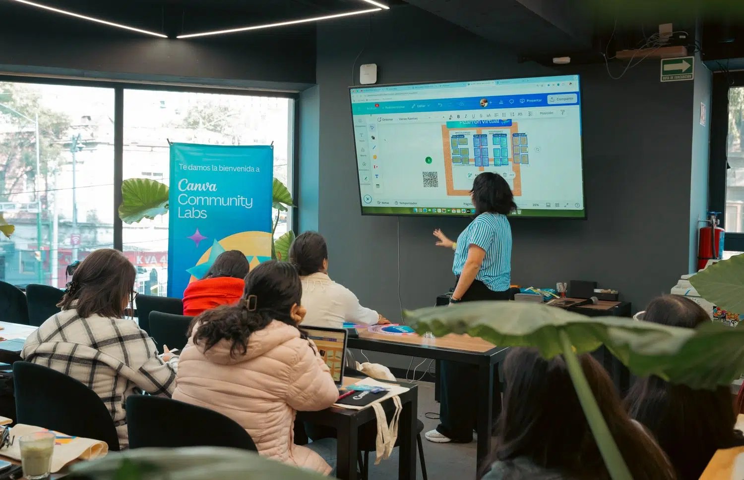 Taller interactivo de presentaciones con una pantalla mostrando un lienzo virtual y audiencia comprometida, ilustrando el dinamismo de herramientas como Prezi. Taller interactivo de presentaciones con una pantalla mostrando un lienzo virtual y audiencia comprometida, ilustrando el dinamismo de herramientas como Prezi.