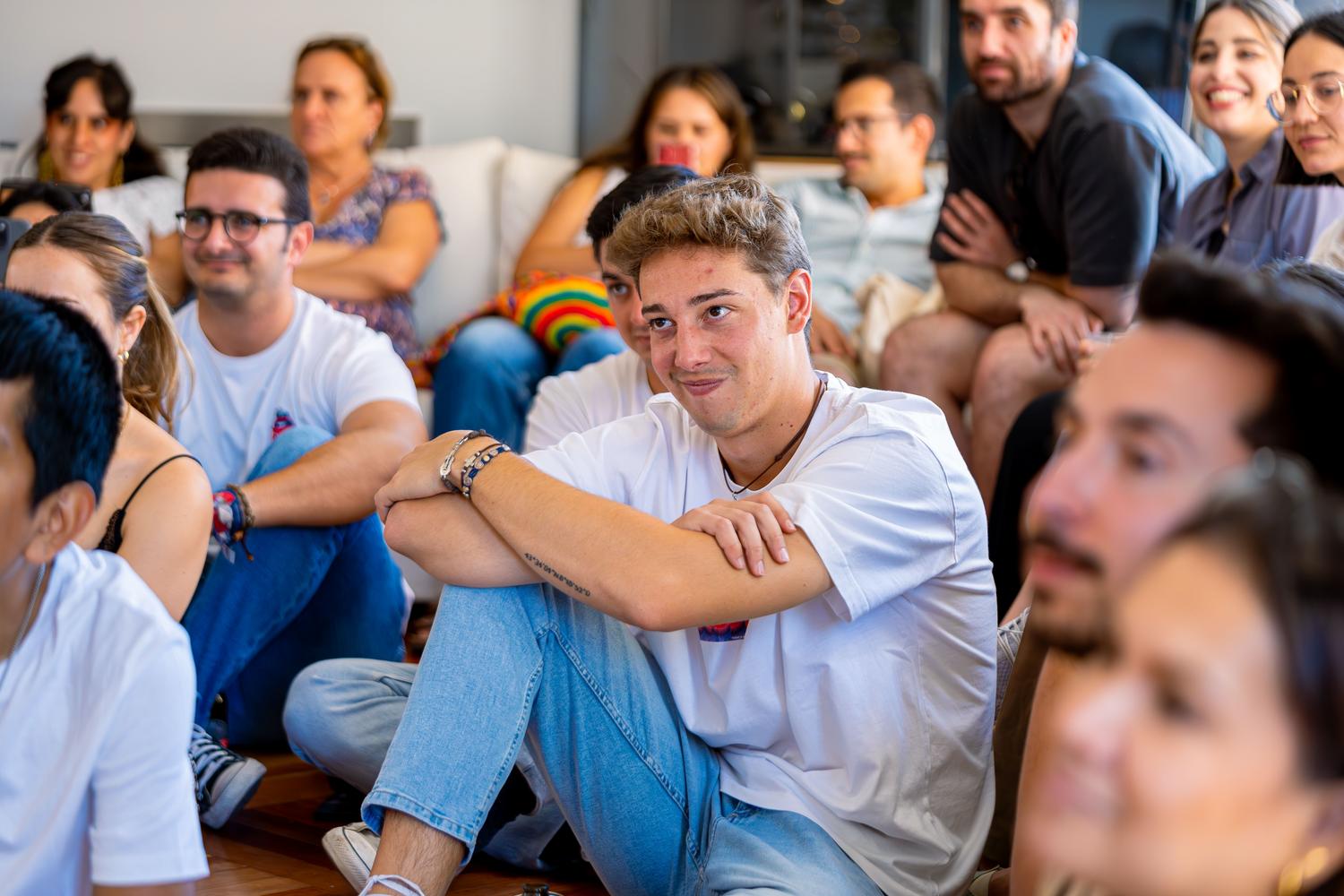 Grupo diverso de personas escuchando atentamente en un ambiente relajado, representando la democratización del saber y la divulgación cultural. Grupo diverso de personas escuchando atentamente en un ambiente relajado, representando la democratización del saber y la divulgación cultural.