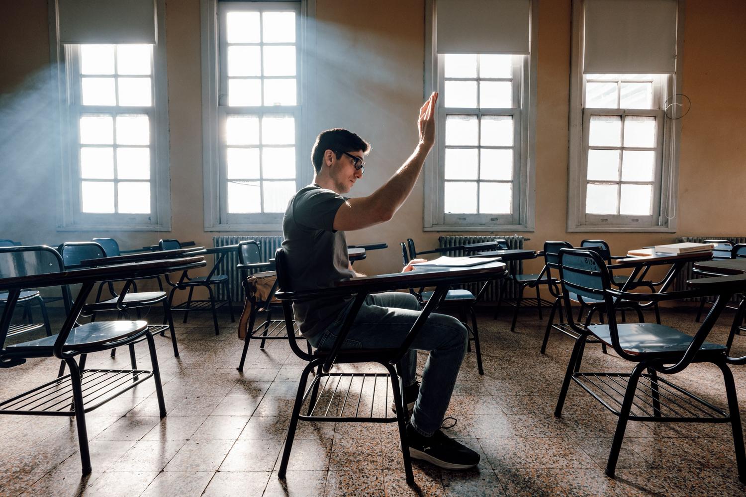 Estudiante participando activamente en un aula universitaria luminosa, simbolizando la curiosidad y el aprendizaje en las cátedras culturales. Estudiante participando activamente en un aula universitaria luminosa, simbolizando la curiosidad y el aprendizaje en las cátedras culturales.