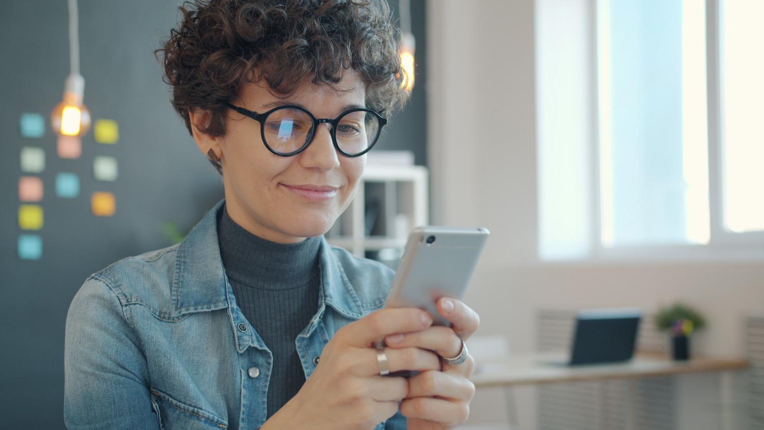 Persona utilizando un teléfono inteligente para acceder a trámites electrónicos de forma rápida y sencilla. Persona utilizando un teléfono inteligente para acceder a trámites electrónicos de forma rápida y sencilla.
