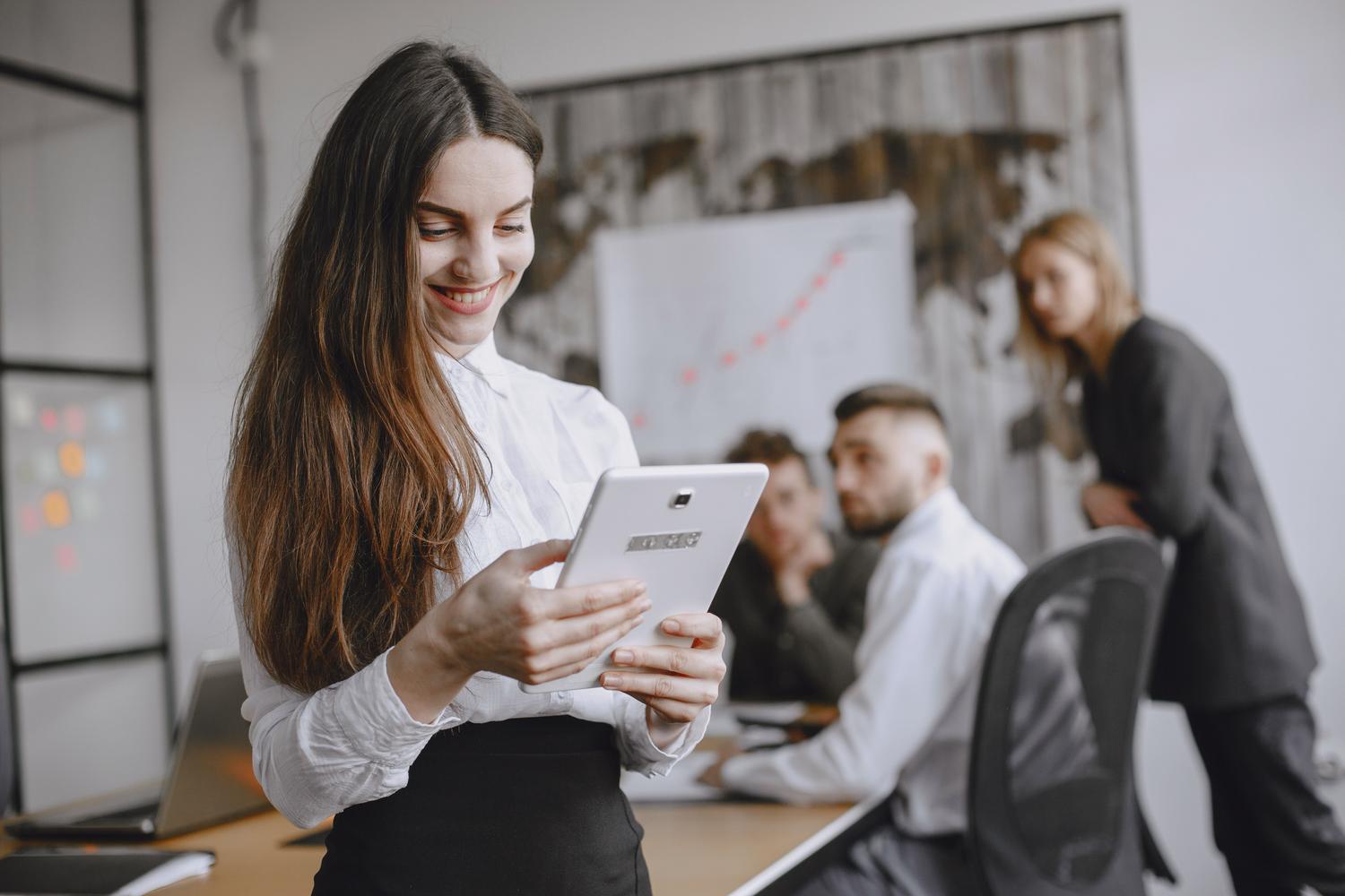 Mujer profesional utilizando una tablet para realizar gestiones administrativas digitales en una oficina. Mujer profesional utilizando una tablet para realizar gestiones administrativas digitales en una oficina.
