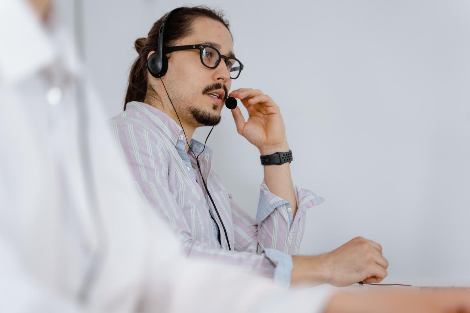 Agente de soporte técnico con auriculares brindando asistencia telefónica al ciudadano. Agente de soporte técnico con auriculares brindando asistencia telefónica al ciudadano.