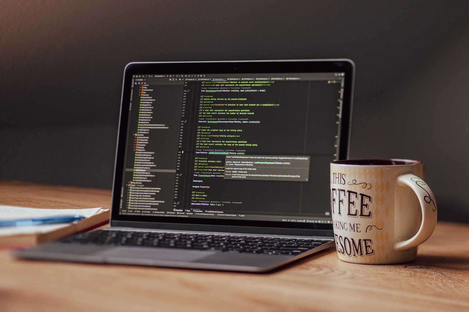 Portátil con editor de código y una taza de café, evocando un entorno de productividad y desarrollo evergreen. Portátil con editor de código y una taza de café, evocando un entorno de productividad y desarrollo evergreen.