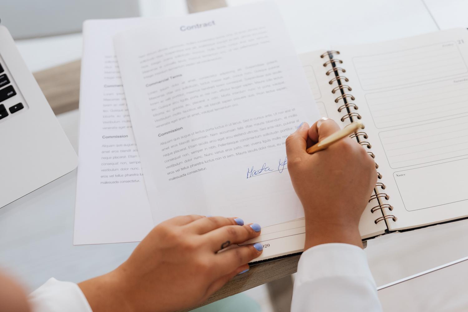 Primer plano de manos firmando un contrato laboral, enfatizando la importancia de contar con un documento escrito y detallado. Primer plano de manos firmando un contrato laboral, enfatizando la importancia de contar con un documento escrito y detallado.