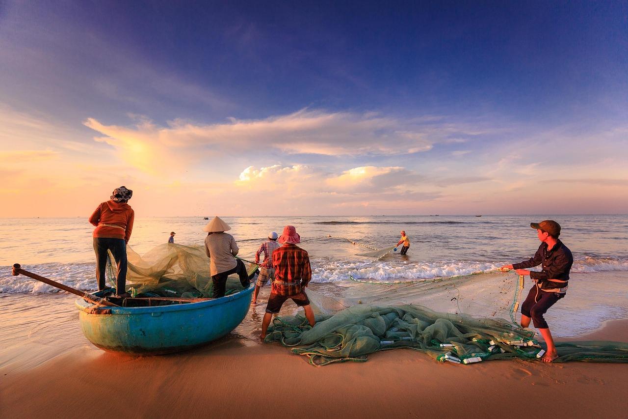 Pescadores con su embarcación en la costa, representando las regulaciones especiales para el sector de la pesca y gente de mar. Pescadores con su embarcación en la costa, representando las regulaciones especiales para el sector de la pesca y gente de mar.