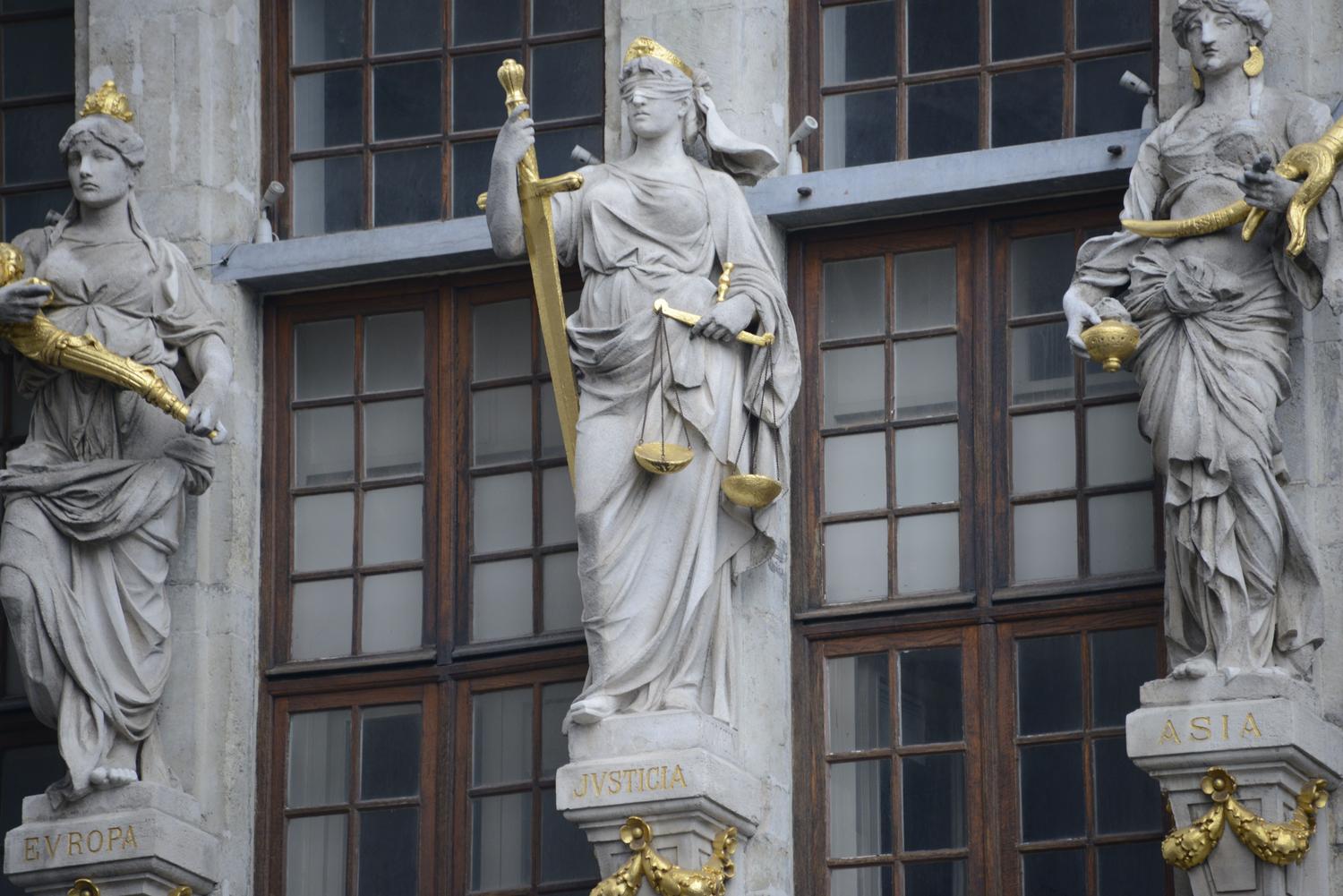 Detalle de estatuas de la Justicia en la fachada de un edificio histórico, simbolizando el marco legal y judicial. Detalle de estatuas de la Justicia en la fachada de un edificio histórico, simbolizando el marco legal y judicial.