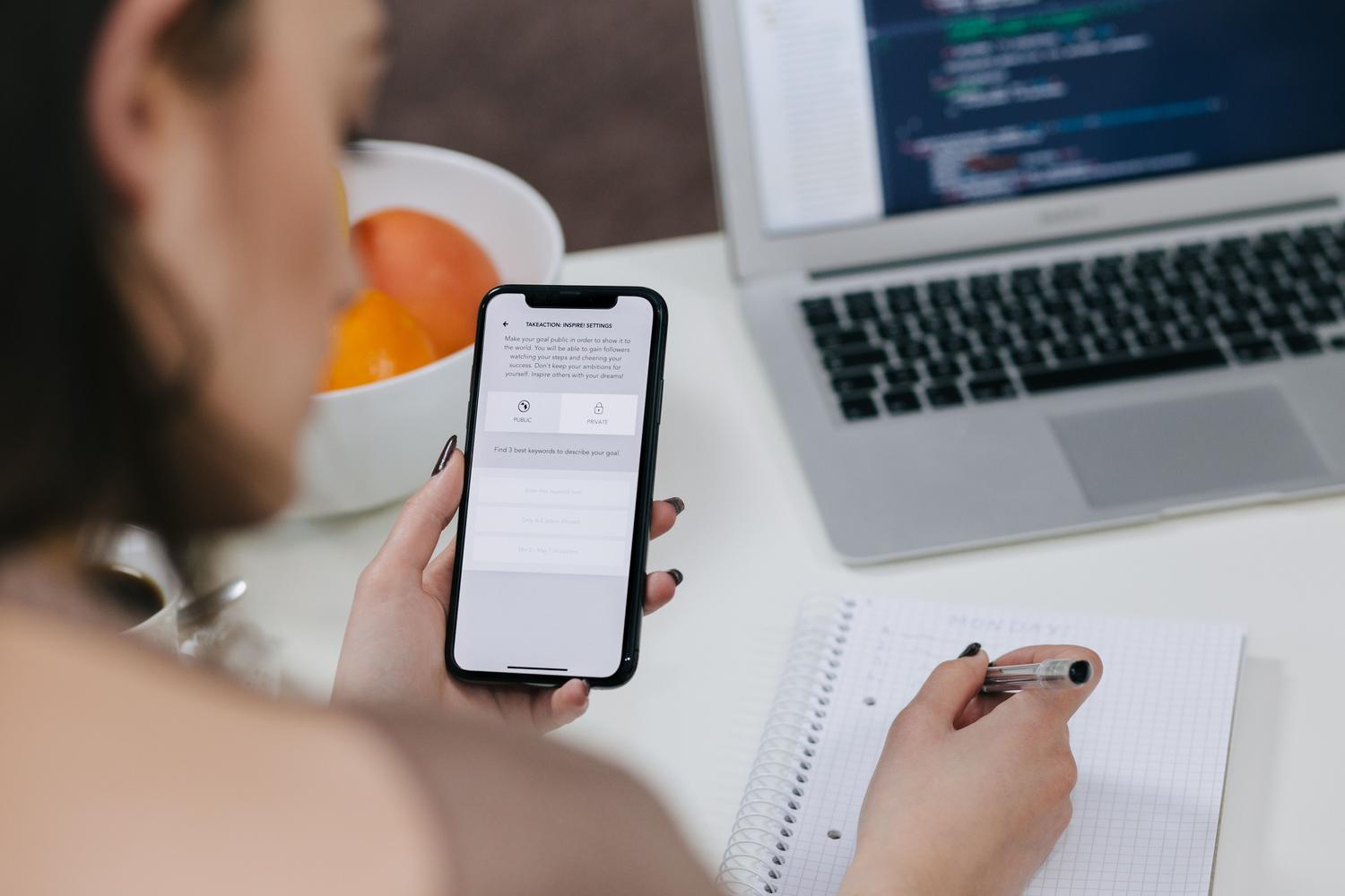 Desarrolladora de software trabajando con un ordenador portátil y un teléfono móvil, ejemplificando el flujo de trabajo multiplataforma para Android e iOS. Desarrolladora de software trabajando con un ordenador portátil y un teléfono móvil, ejemplificando el flujo de trabajo multiplataforma para Android e iOS.