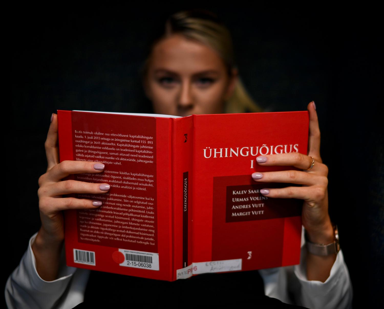 Estudiante de derecho concentrado leyendo un libro de texto jurídico en una biblioteca, representando la fase de investigación del doctorado. Estudiante de derecho concentrado leyendo un libro de texto jurídico en una biblioteca, representando la fase de investigación del doctorado.