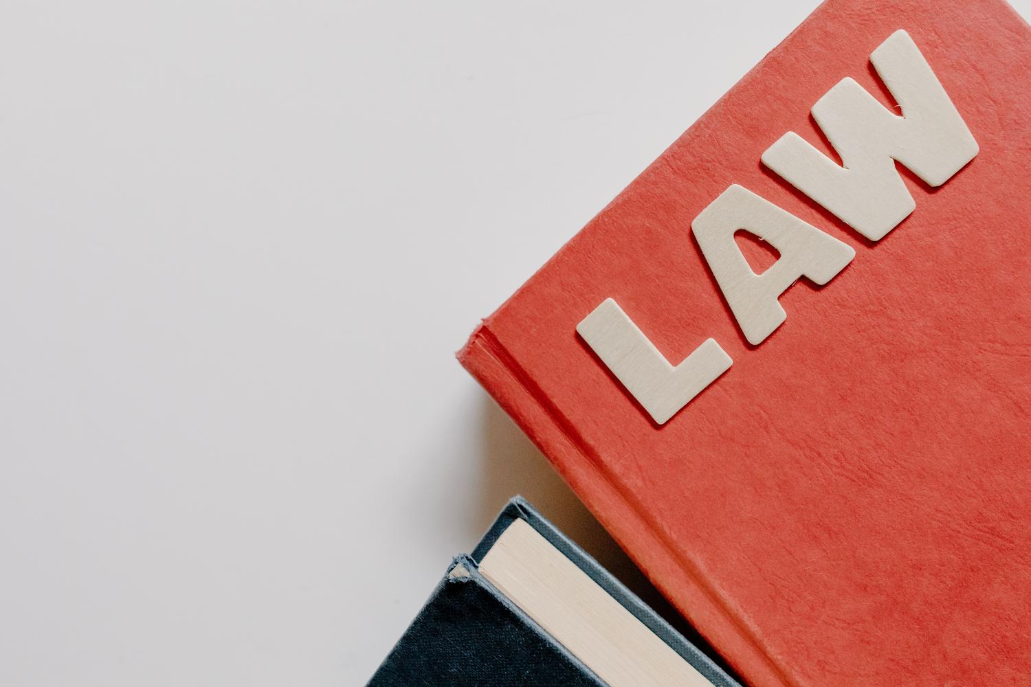 Primer plano de un libro de derecho con la palabra 'LAW', simbolizando la base teórica y la formación académica superior. Primer plano de un libro de derecho con la palabra 'LAW', simbolizando la base teórica y la formación académica superior.