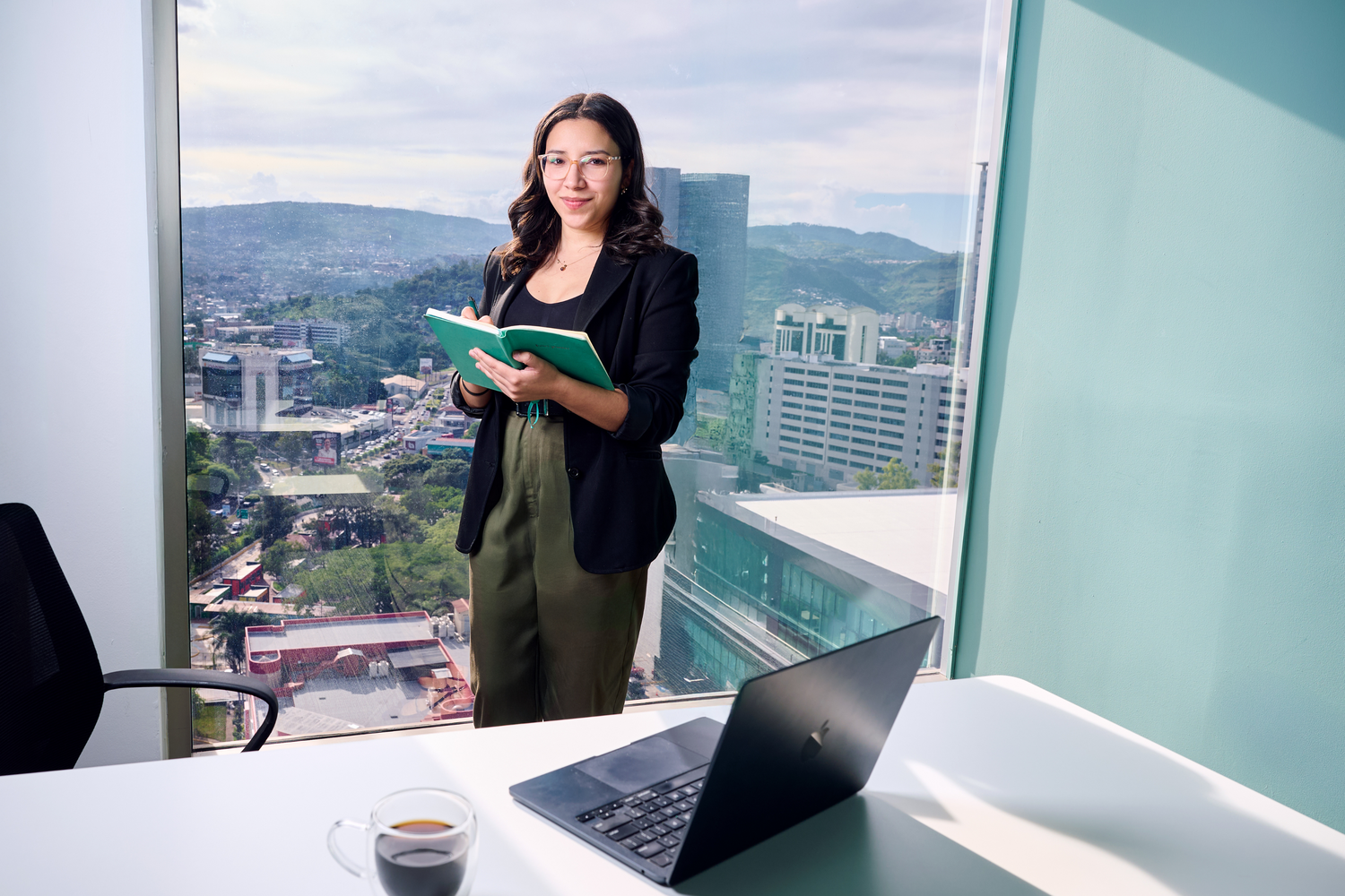 Mujer profesional en una oficina moderna con vistas panorámicas a una ciudad internacional. Mujer profesional en una oficina moderna con vistas panorámicas a una ciudad internacional.