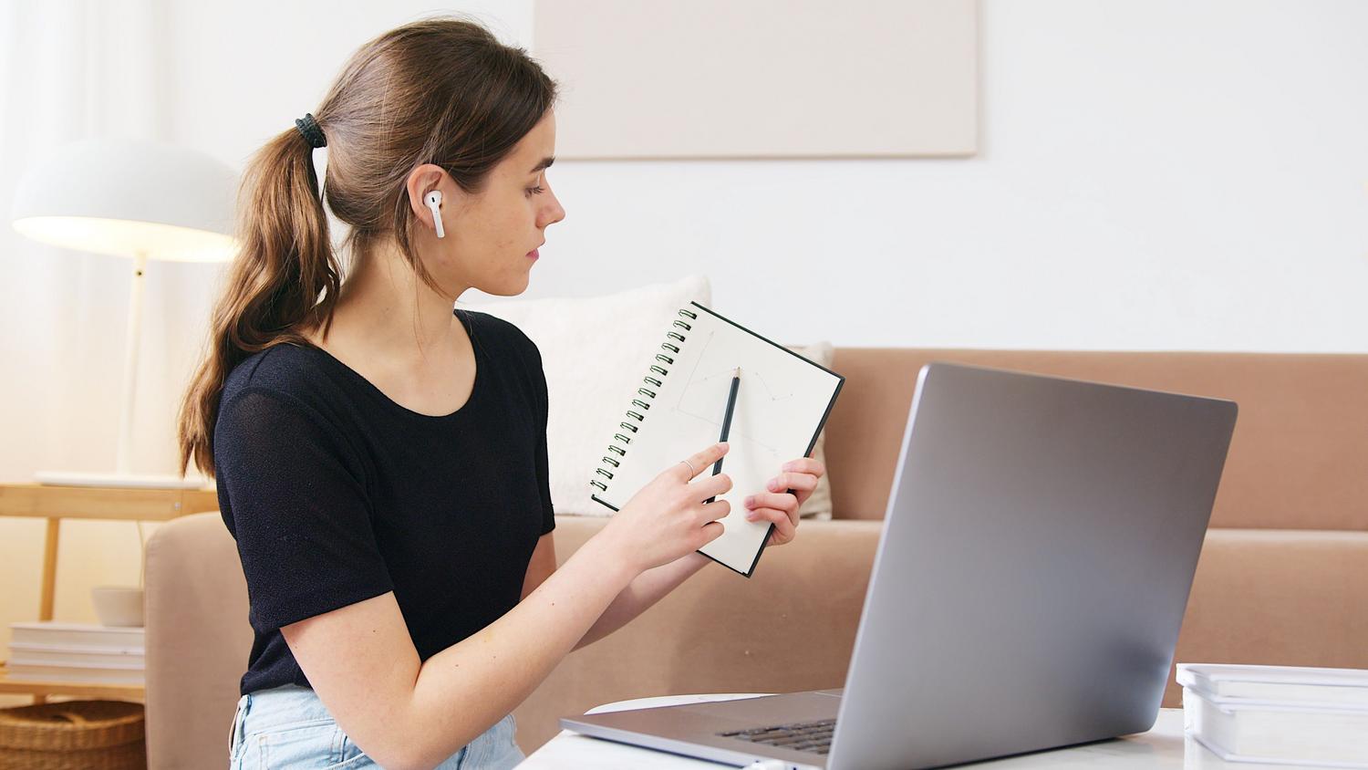 Estudiante concentrada con auriculares siguiendo un webinar de economía, reflejando la metodología de aprendizaje digital. Estudiante concentrada con auriculares siguiendo un webinar de economía, reflejando la metodología de aprendizaje digital.
