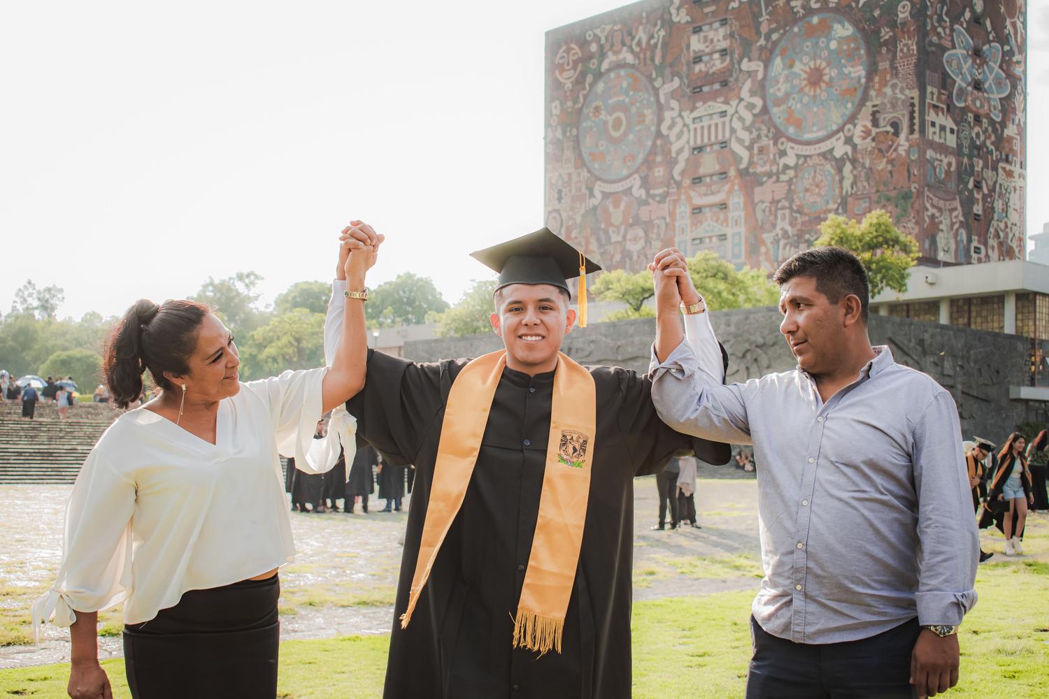 Graduado universitario celebrando su éxito junto a sus padres, simbolizando el objetivo final tras superar las notas de corte y completar la carrera. Graduado universitario celebrando su éxito junto a sus padres, simbolizando el objetivo final tras superar las notas de corte y completar la carrera.