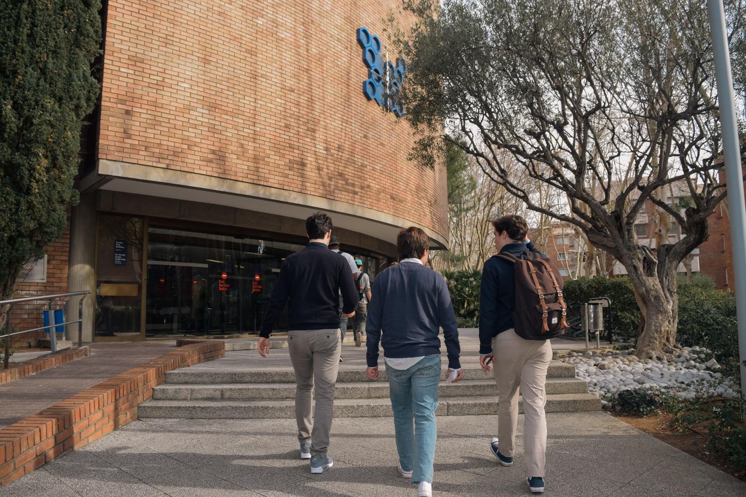 Tres estudiantes entrando en un edificio universitario, simbolizando el acceso a la educación superior y la superación de las notas de corte. Tres estudiantes entrando en un edificio universitario, simbolizando el acceso a la educación superior y la superación de las notas de corte.