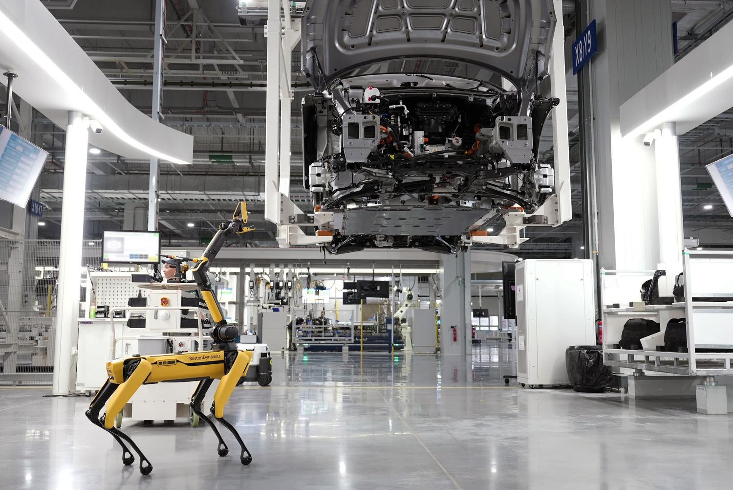 Perro robótico supervisando el ensamblaje automatizado de coches en una fábrica de alta tecnología, representando la Physical AI en la industria. Perro robótico supervisando el ensamblaje automatizado de coches en una fábrica de alta tecnología, representando la Physical AI en la industria.