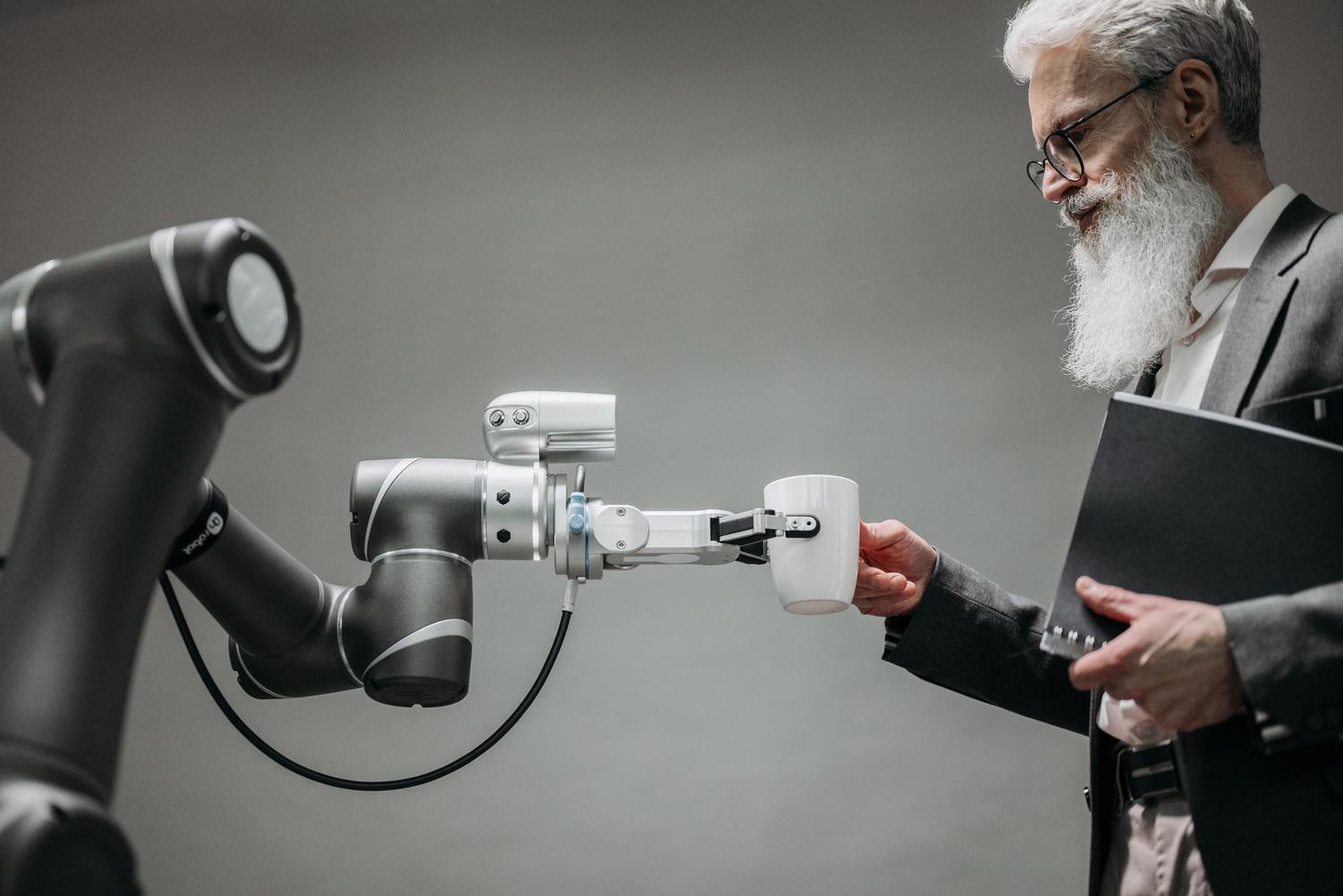 Brazo robótico asistiendo a una persona en un entorno moderno, representando la aplicación de la Physical AI en el sector salud y asistencial. Brazo robótico asistiendo a una persona en un entorno moderno, representando la aplicación de la Physical AI en el sector salud y asistencial.