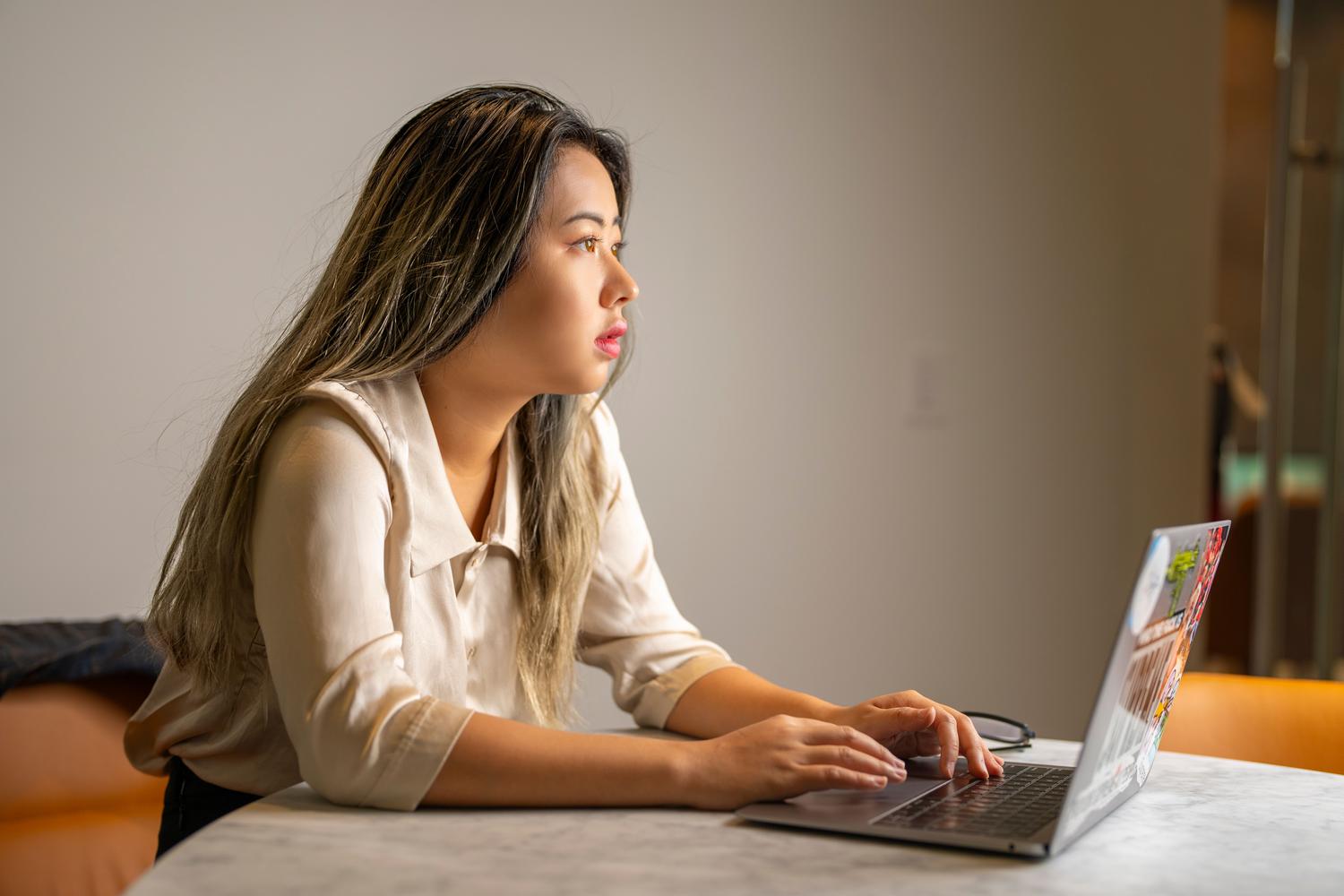 Profilo e ambiente di lavoro dell'ingegnere di apprendimento automatico Professionista del settore tecnologico, concentrato e intento a lavorare con un laptop in un ufficio moderno, a rispecchiare il profilo e l'ambiente di lavoro di un ingegnere di machine learning.