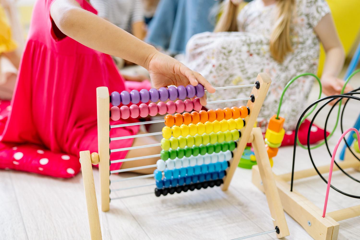 Niños pequeños aprendiendo matemáticas de forma lúdica utilizando un ábaco colorido en un entorno preescolar Niños pequeños aprendiendo matemáticas de forma lúdica utilizando un ábaco colorido en un entorno preescolar