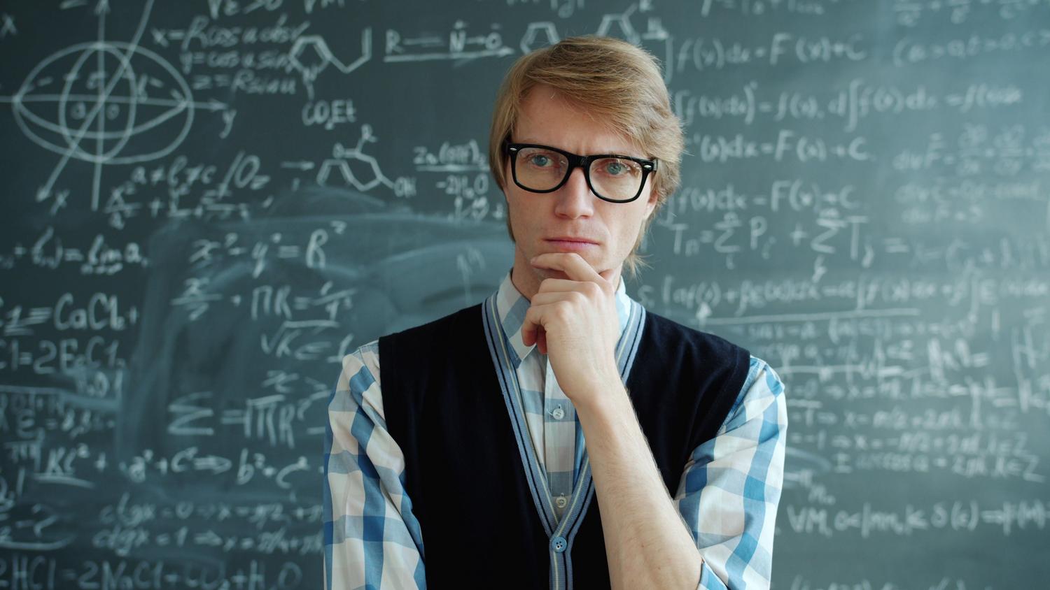 Profesor reflexivo frente a una pizarra con ecuaciones complejas, ilustrando el rol del docente como guía que facilita el razonamiento. Profesor reflexivo frente a una pizarra con ecuaciones complejas, ilustrando el rol del docente como guía que facilita el razonamiento.