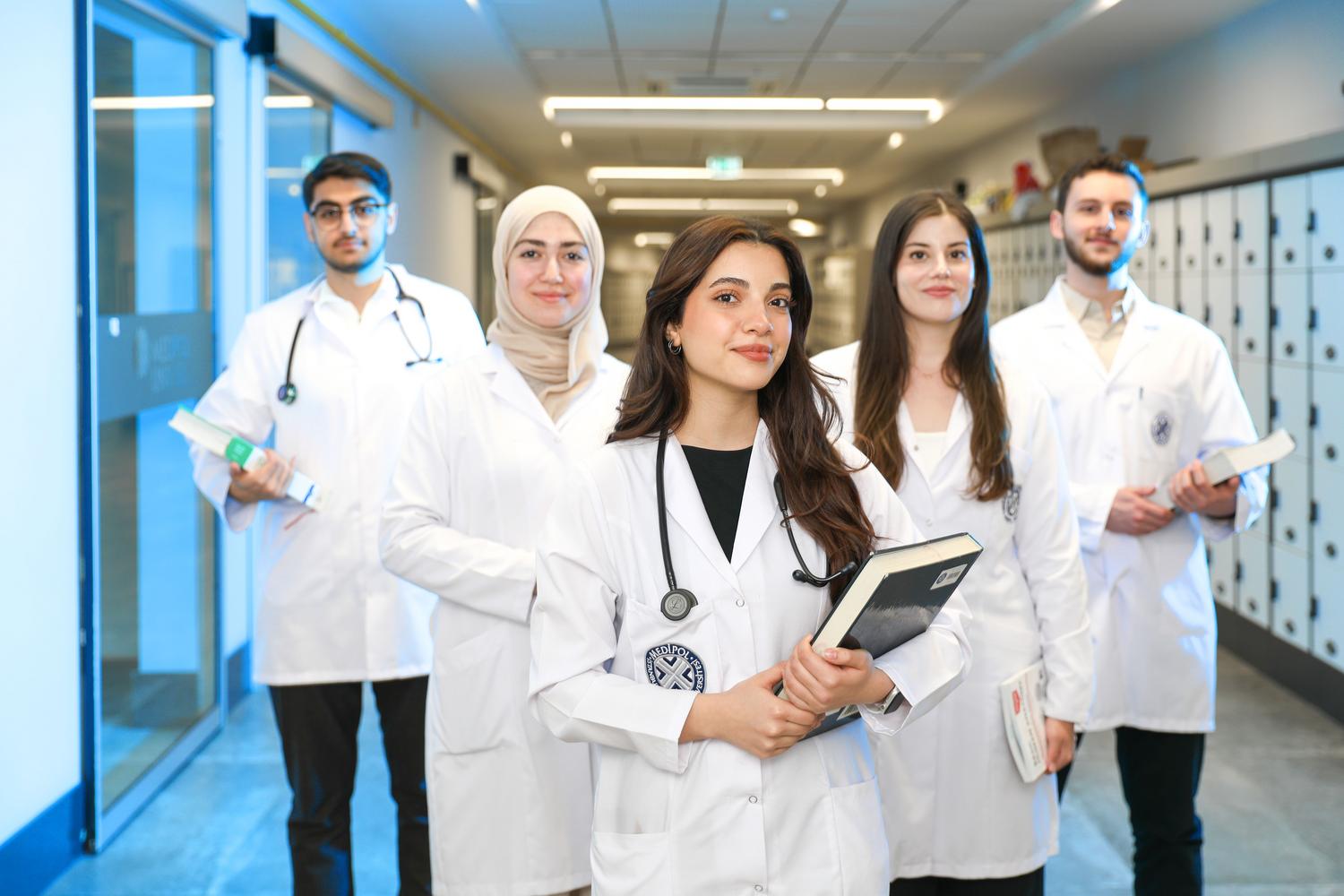 Grupo de estudiantes de medicina en un pasillo universitario, simbolizando la formación profesional y las certificaciones de calidad. Grupo de estudiantes de medicina en un pasillo universitario, simbolizando la formación profesional y las certificaciones de calidad.