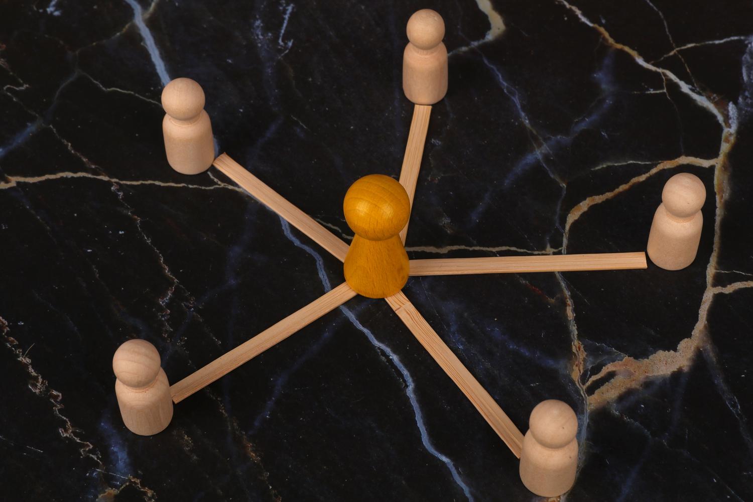 Representación conceptual de una comunidad digital mediante figuras de madera conectadas, simbolizando el puente entre la marca y sus usuarios. Representación conceptual de una comunidad digital mediante figuras de madera conectadas, simbolizando el puente entre la marca y sus usuarios.