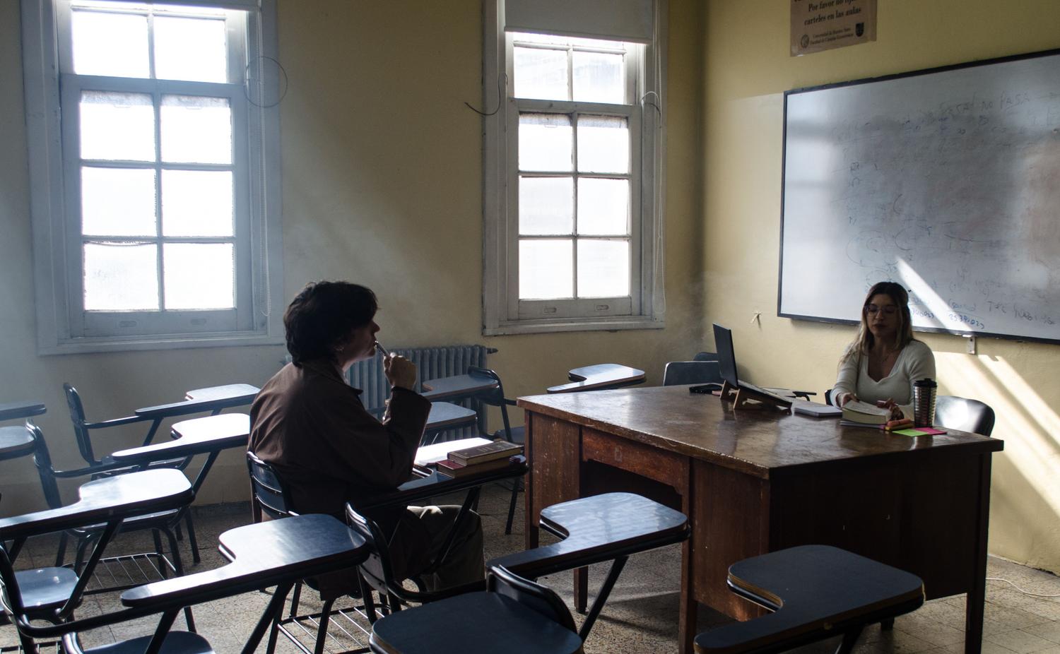 Dos estudiantes universitarios manteniendo una conversación reflexiva en un aula, ilustrando la capacidad de análisis crítico. Dos estudiantes universitarios manteniendo una conversación reflexiva en un aula, ilustrando la capacidad de análisis crítico.