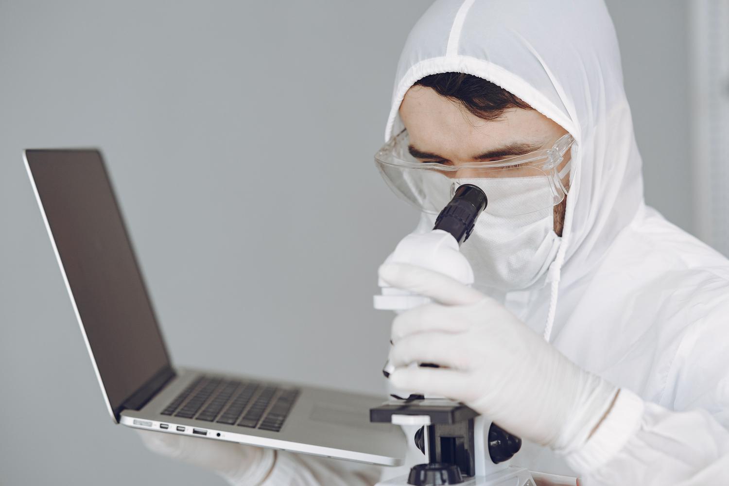 Científico en un laboratorio utilizando un microscopio y un ordenador portátil para analizar datos de investigación. Científico en un laboratorio utilizando un microscopio y un ordenador portátil para analizar datos de investigación.