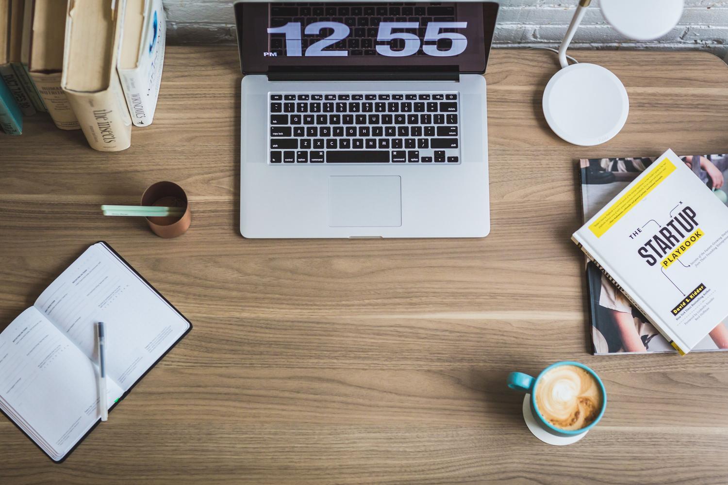 Espacio de trabajo digital con portátil y libros de emprendimiento, ideal para negocios de bajo capital Espacio de trabajo digital con portátil y libros de emprendimiento, ideal para negocios de bajo capital