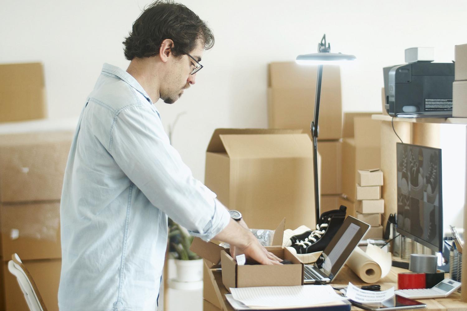 Emprendedor preparando pedidos de su tienda online desde un despacho en casa Emprendedor preparando pedidos de su tienda online desde un despacho en casa
