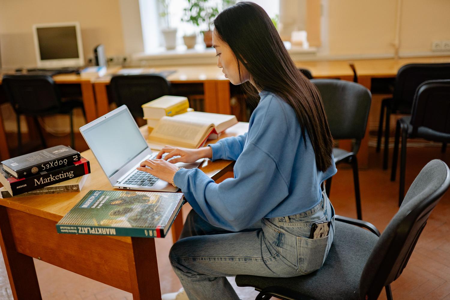 A focused student with a laptop and books in a cozy space, illustrating the flexibility of online study. A focused student with a laptop and books in a cozy space, illustrating the flexibility of online study.