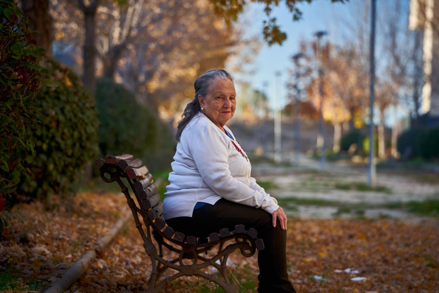 Mujer mayor sentada reflexiva en un banco de parque durante el otoño, representando la situación de viudedad. Mujer mayor sentada reflexiva en un banco de parque durante el otoño, representando la situación de viudedad.