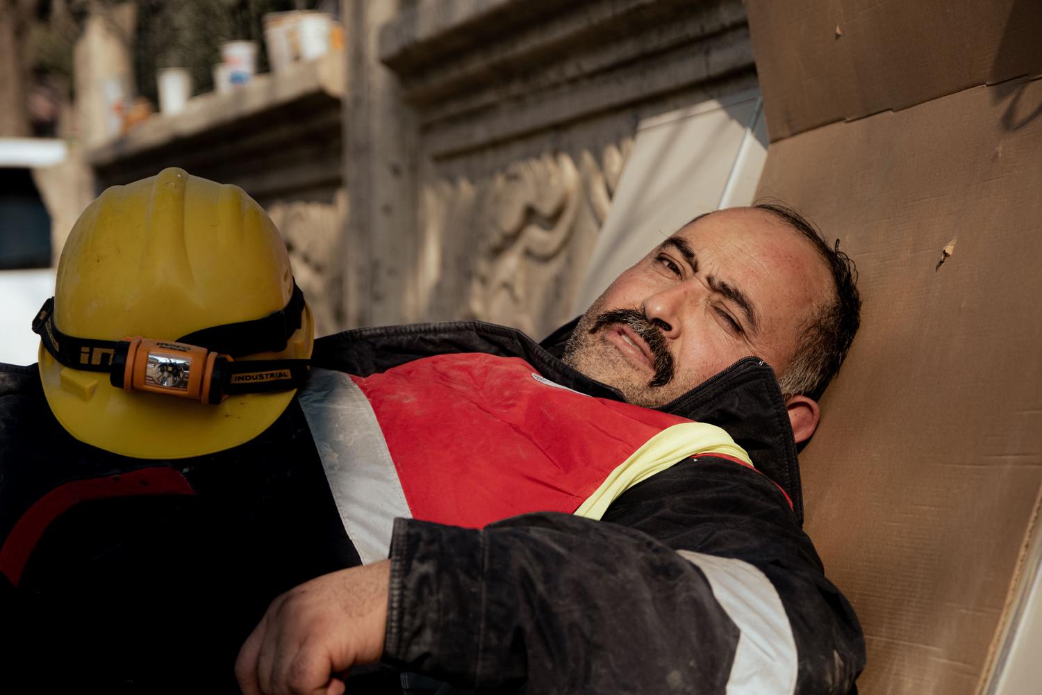 Construction worker resting on a piece of cardboard on the ground, symbolizing precariousness and lack of decent conditions. Construction worker resting on a piece of cardboard on the ground, symbolizing precariousness and lack of decent conditions.