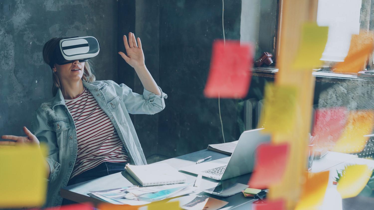 Profesional utilizando un casco de realidad virtual en una oficina para brainstorming, mostrando aplicaciones más allá del gaming. Profesional utilizando un casco de realidad virtual en una oficina para brainstorming, mostrando aplicaciones más allá del gaming.
